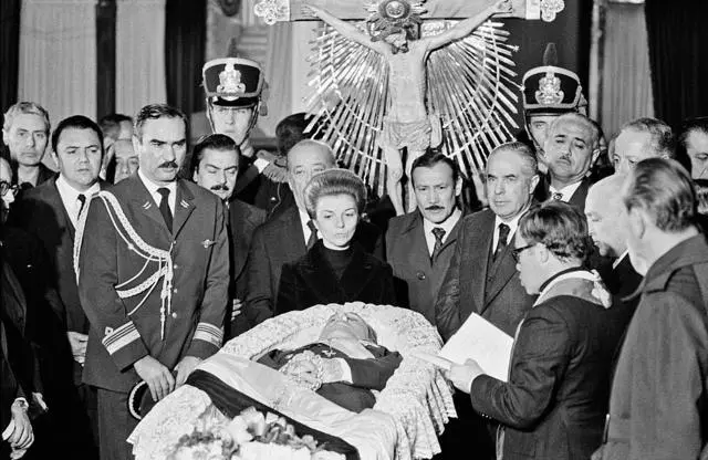 صورة تعود لـ 3 يوليو من عام 1974 لإيزابيل بيرون (في الوسط)، الرئيسة الجديدة لجمهورية الأرجنتين، بالقرب من جثمان زوجها الراحل، الرئيس السابق خوان بيرون