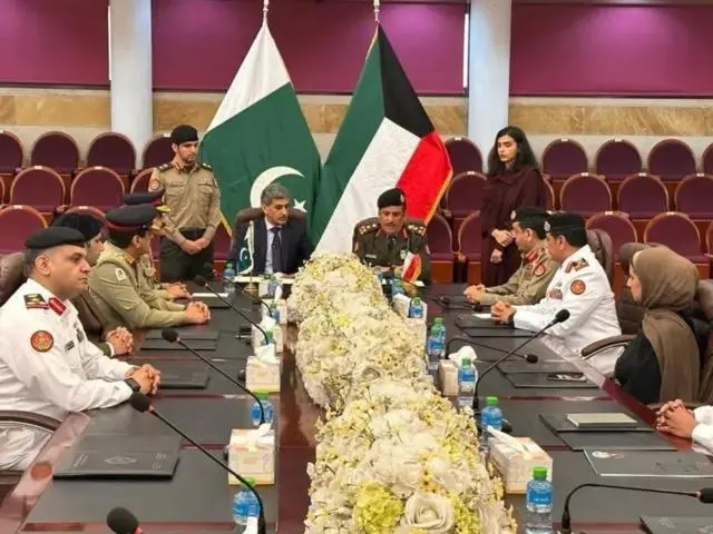 مجموعة من المسؤولين الكويتيين والباكستانيين بينهم سيدتان على طاولة اجتماعات وخلفهما العلم الكويتي والباكستاني.
