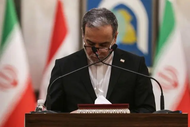 عراقجي ينظر إلى ملاحظاته خلال مؤتمر صحفي مع نظيره العراقي في بغداد، بالتزامن مع استمرار المفاوضات بشأن الحرب وتوتر الملاحة في مضيق هرمز.