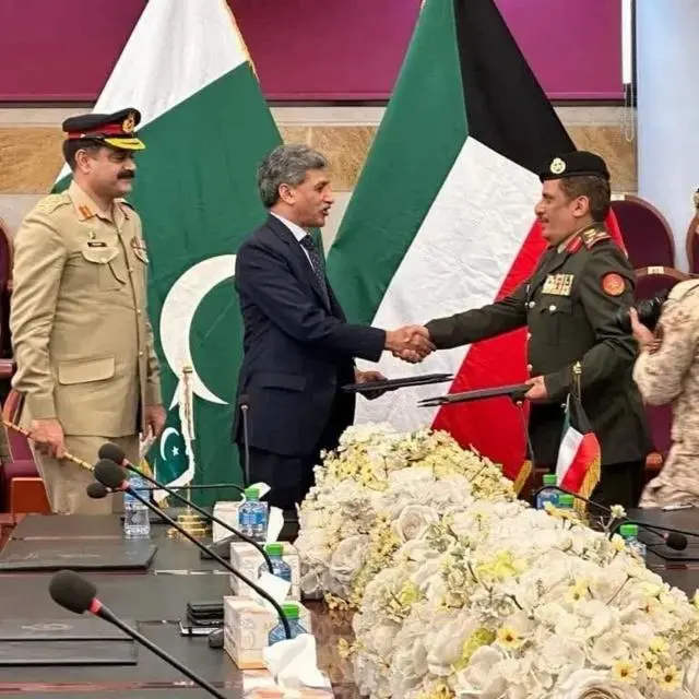 مسؤولون عسكريون من باكستان والكويت يجتمعون وخلفهم علم الكويت وباكستان.